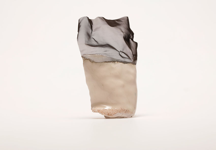 An object consisting of ceramic at the bottom and textile at the top against a white background.